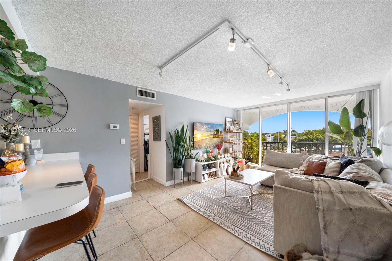 2150 Southwest 16th Avenue, Unit 402 Miami, FL 33145 - Photo 6 of 25 a living room with furniture a chandelier and a dining table