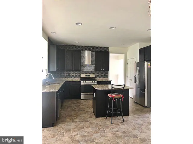 a large kitchen with cabinets and stainless steel appliances