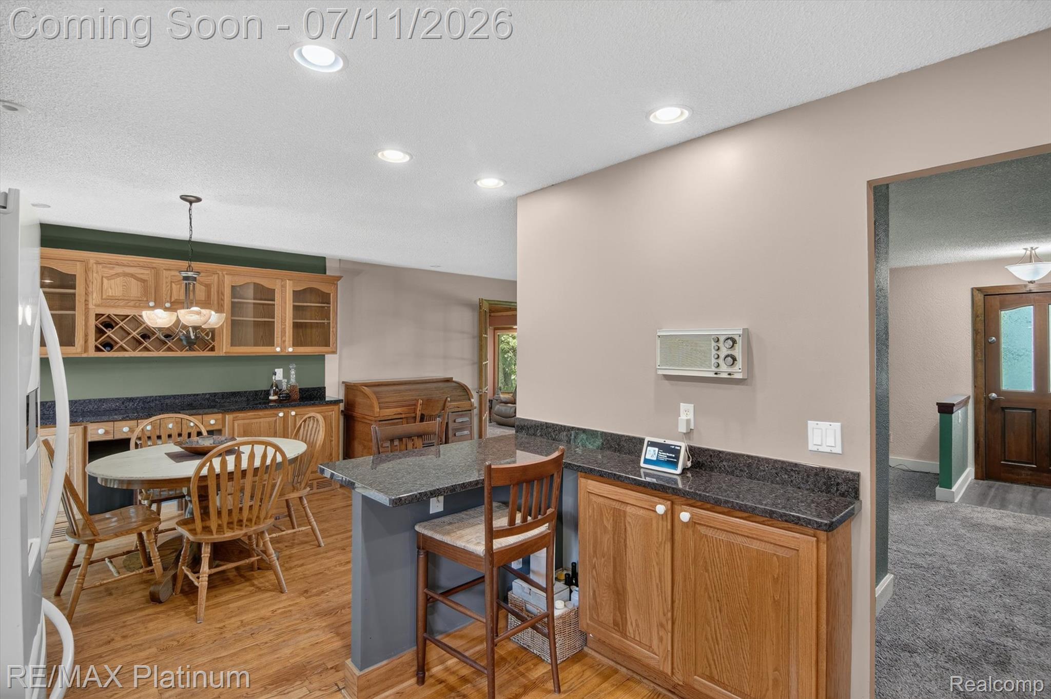 13365 North Territorial Road Gregory, MI 48137 - Photo 20 of 52 Kitchen area featuring wood-finish flooring, recessed lighting, and a breakfast bar with a dark stone countertop