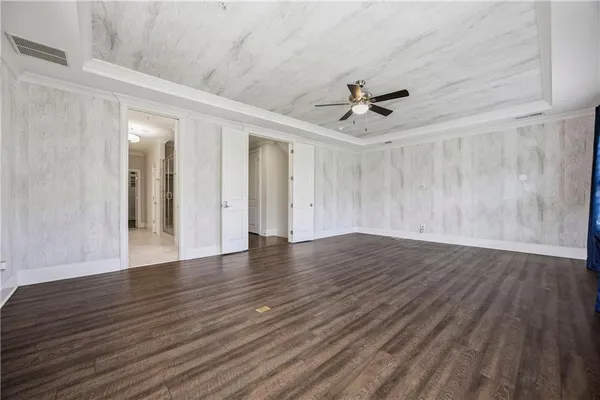 wooden floor in an empty room with a ceiling fan