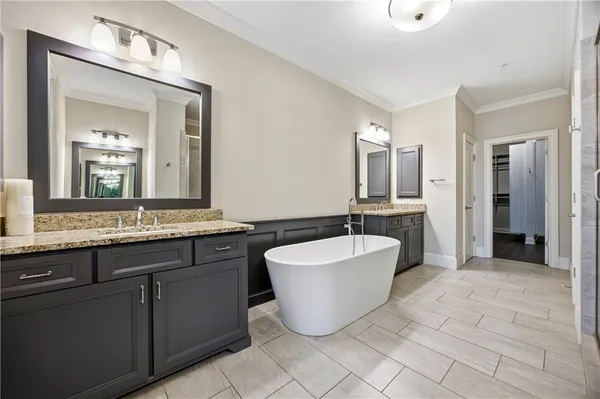 a spacious bathroom with a double vanity sink mirror and bathtub