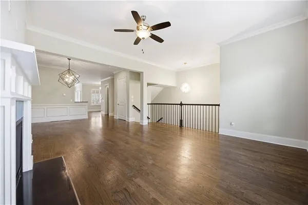 a view of a livingroom with wooden floor and a ceiling fan