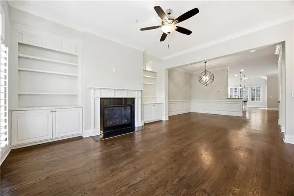 a view of a livingroom with a fireplace a ceiling fan and hardwood floor