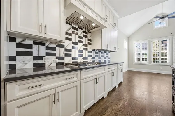 a kitchen with stainless steel appliances granite countertop a sink and wooden cabinets