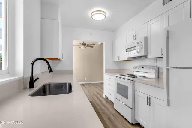 a kitchen with white cabinets and white appliances