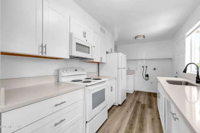 a kitchen with stainless steel appliances granite countertop white cabinets sink and stove