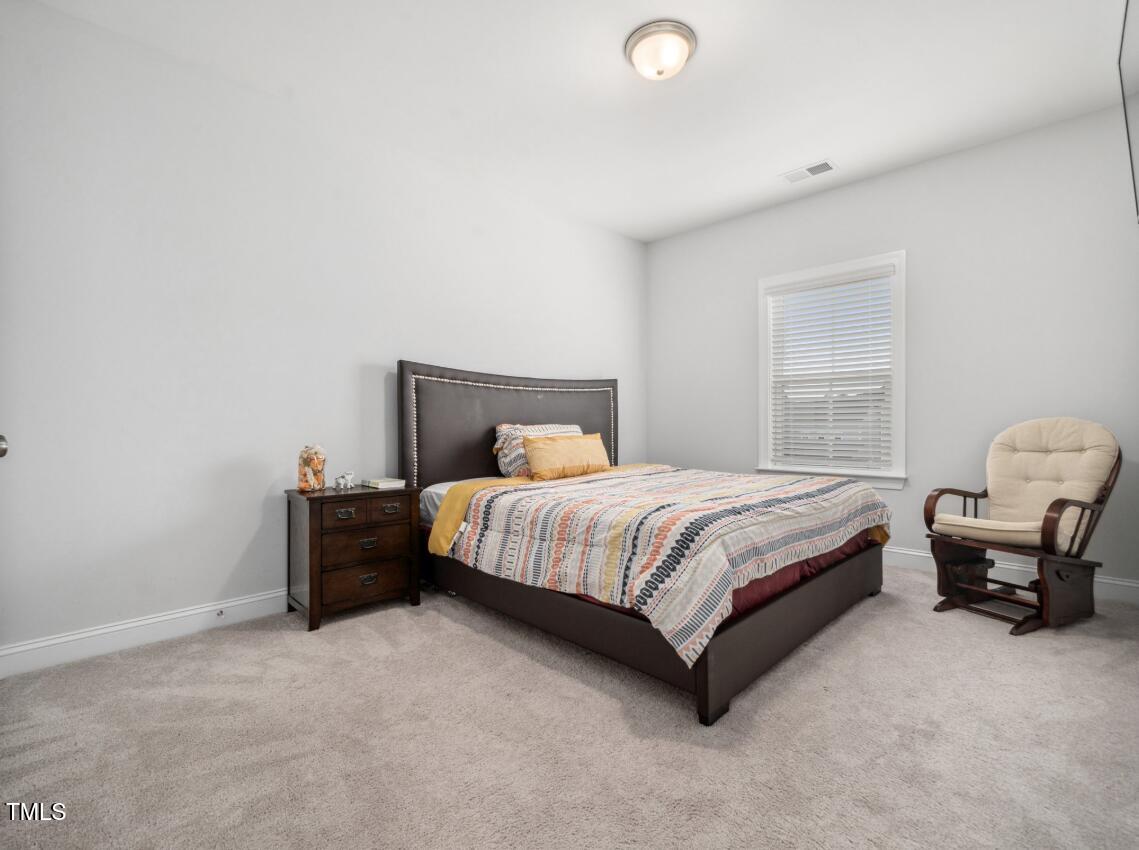 2609 Princess Tree Drive Raleigh, NC 27616 - Photo 18 of 23 a bedroom with a bed lamp and a couch