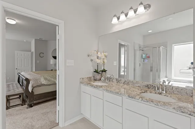 a bathroom with double vanity sinks a vanity a lamp and a mirror