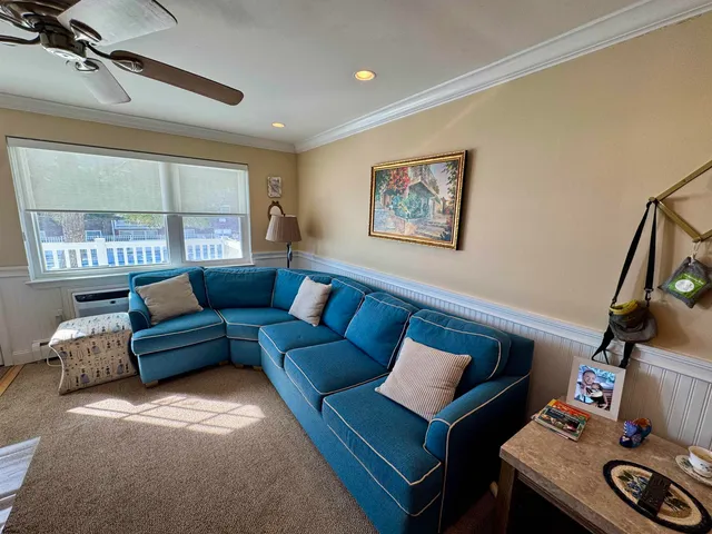 a living room with furniture a large window and a flat screen tv