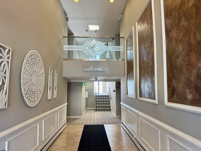 a kitchen with stainless steel appliances granite countertop a table chairs wooden floors a refrigerator and cabinets