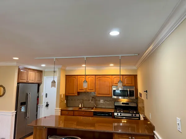 a kitchen with stainless steel appliances granite countertop a refrigerator and a sink