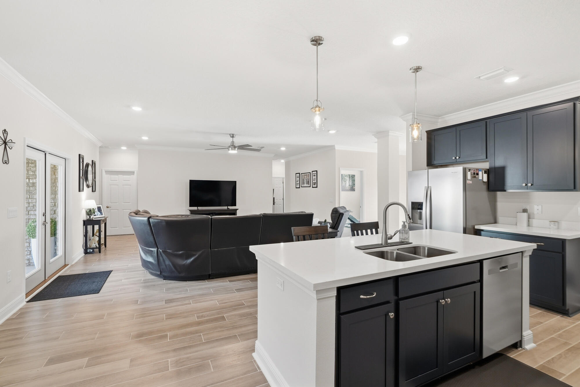 158 Bentgrass Road South Freeport, FL 32439 - Photo 17 of 66 a kitchen with stainless steel appliances kitchen island granite countertop a sink a stove a refrigerator and a dining table with wooden floor