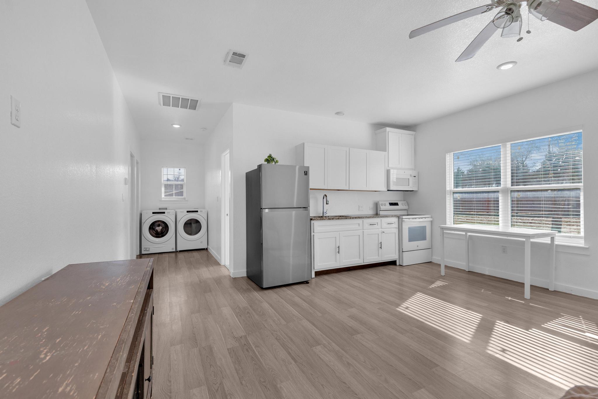 114 Crepe Myrtle Parkway Elgin, TX 78621 - Photo 6 of 40 Unit A - Kitchen featuring white appliances, white cabinetry, separate washer and dryer, light wood-type flooring, and ceiling fan