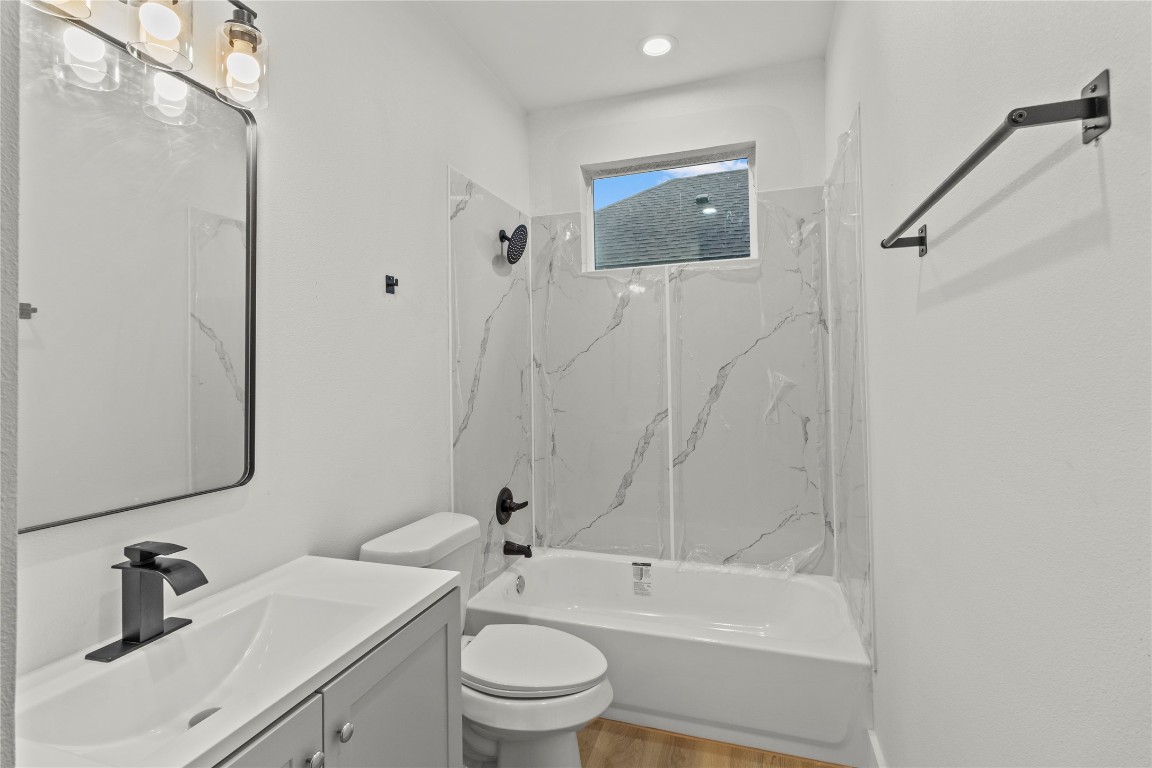8129 Hoffman Street Houston, TX 77016 - Photo 13 of 18 a bathroom with a toilet a sink a mirror and bathtub