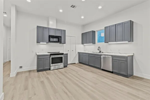 a kitchen with stainless steel appliances a stove top oven and sink