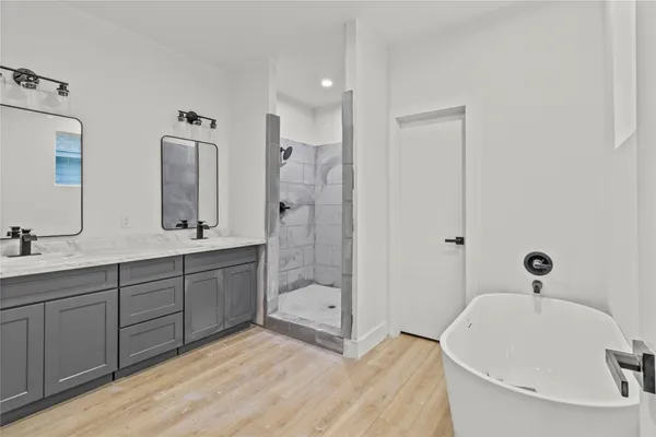 a bathroom with a tub sink and mirror