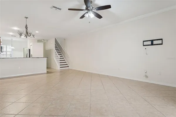 an empty room with wooden floor and fan
