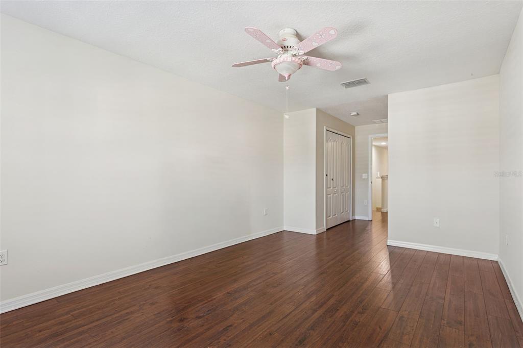 9568 Trumpet Vine Loop Trinity, FL 34655 - Photo 13 of 25 an empty room with wooden floor and fan