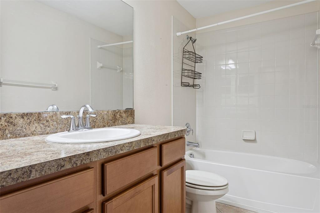 9568 Trumpet Vine Loop Trinity, FL 34655 - Photo 15 of 25 a bathroom with a granite countertop sink a toilet and shower
