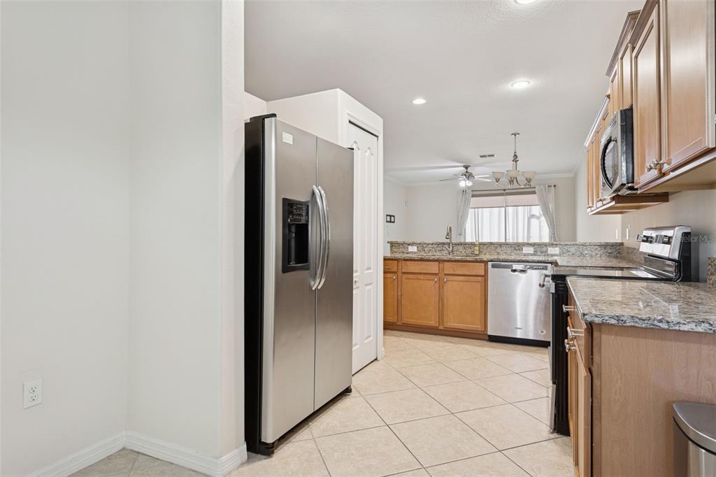 9568 Trumpet Vine Loop Trinity, FL 34655 - Photo 5 of 25 a kitchen with stainless steel appliances granite countertop a refrigerator sink and stove