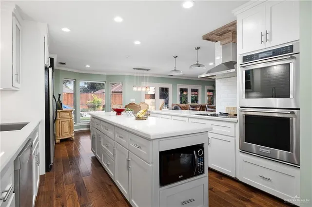 a kitchen with kitchen island stainless steel appliances a stove sink and microwave