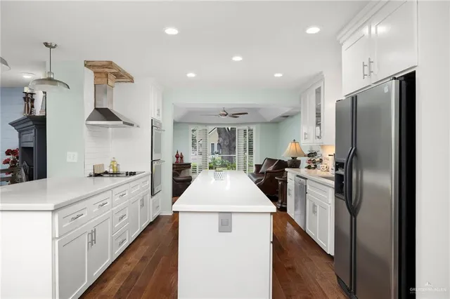 a kitchen with kitchen island stainless steel appliances a sink stove and refrigerator
