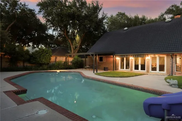 a view of a house with swimming pool and a yard