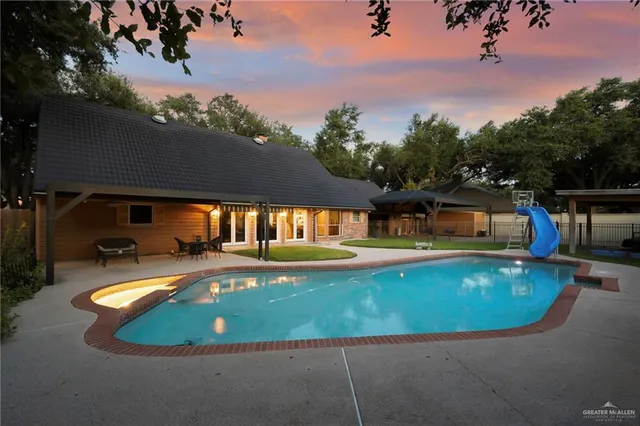 an aerial view of a house with swimming pool garden view and trees