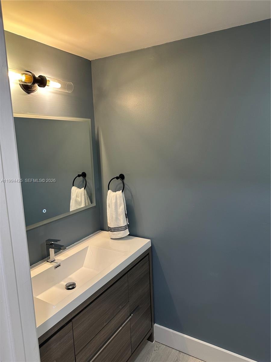 3339 Virginia Street, Unit 127 Miami, FL 33133 - Photo 12 of 25 a bathroom with a sink and a mirror