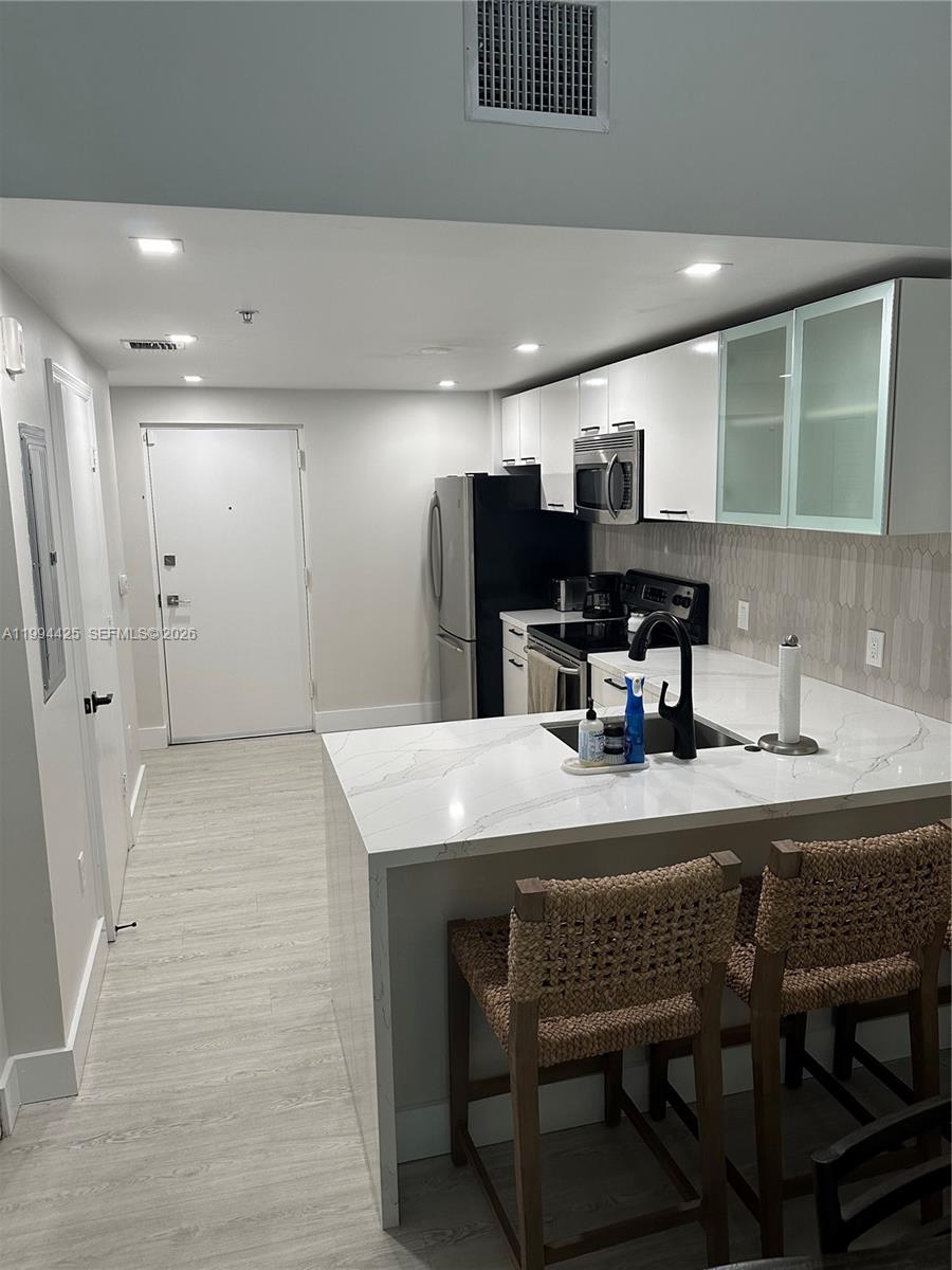 3339 Virginia Street, Unit 127 Miami, FL 33133 - Photo 7 of 25 a kitchen with a table chairs and refrigerator
