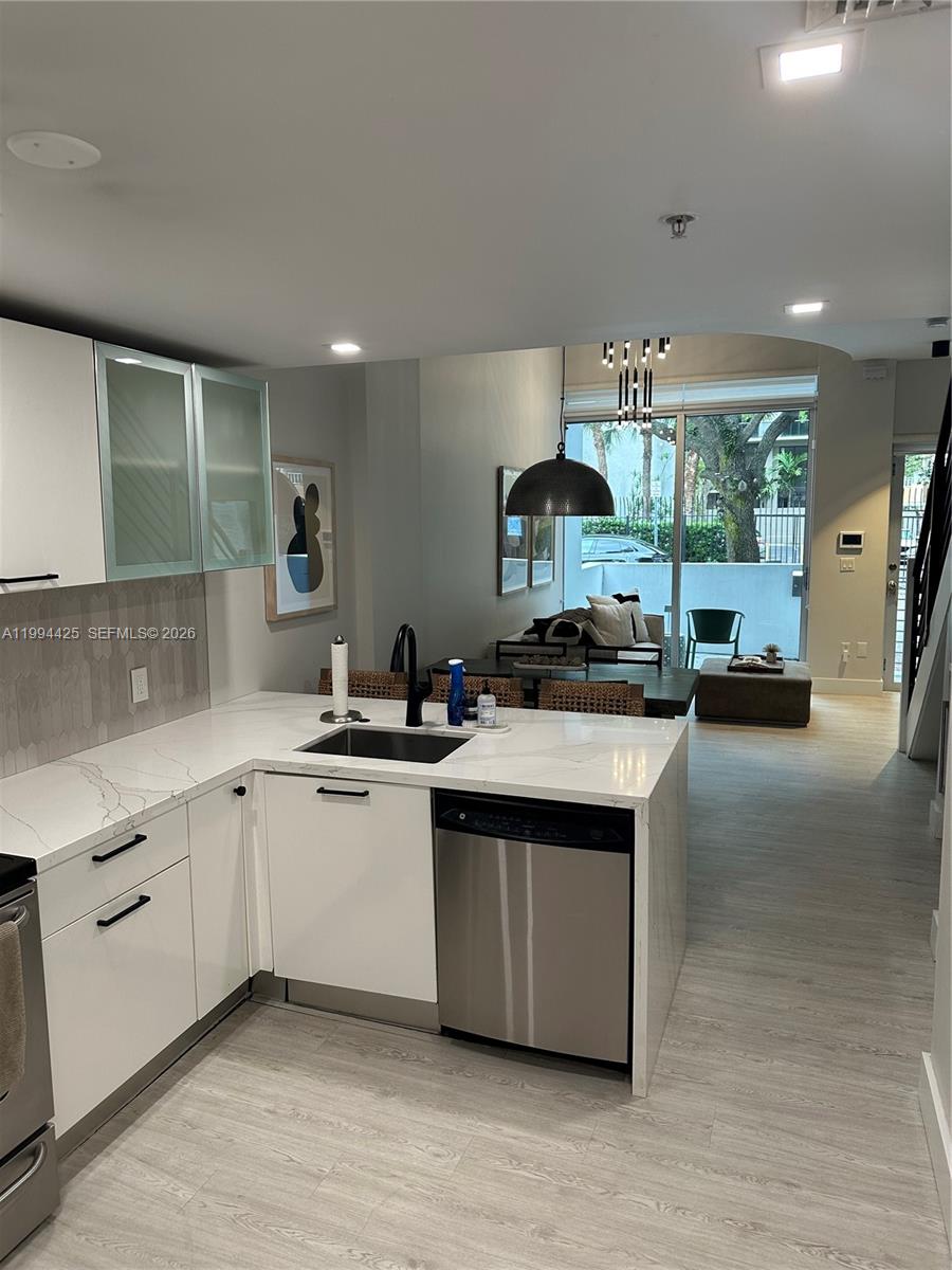 3339 Virginia Street, Unit 127 Miami, FL 33133 - Photo 9 of 25 a kitchen with stainless steel appliances granite countertop a sink stove and cabinets
