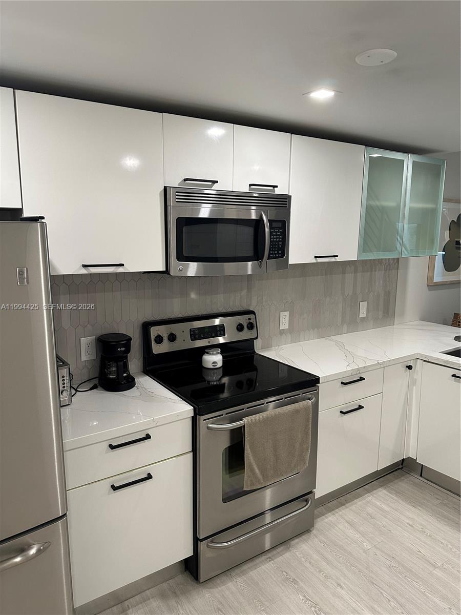 3339 Virginia Street, Unit 127 Miami, FL 33133 - Photo 10 of 25 a kitchen with a stove microwave and sink