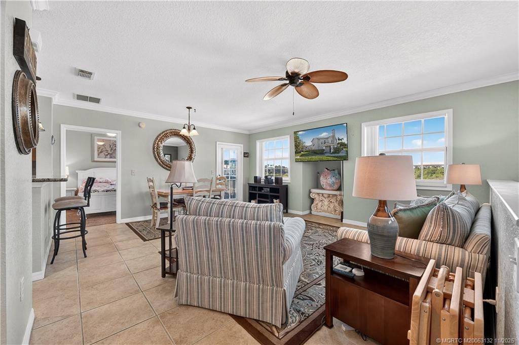 160 Southwest Peacock Boulevard, Unit 31203 Port St. Lucie, FL 34986 - Photo 11 of 43 a living room with furniture a ceiling fan and a window
