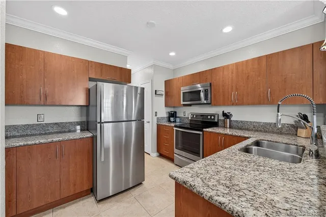 a kitchen with a refrigerator sink and wooden cabinets