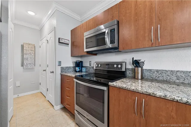a kitchen with stainless steel appliances granite countertop a stove microwave and refrigerator
