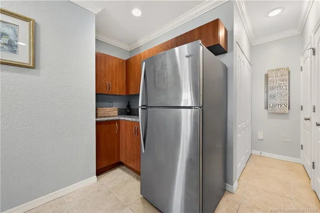 a view of a refrigerator in kitchen and an empty room
