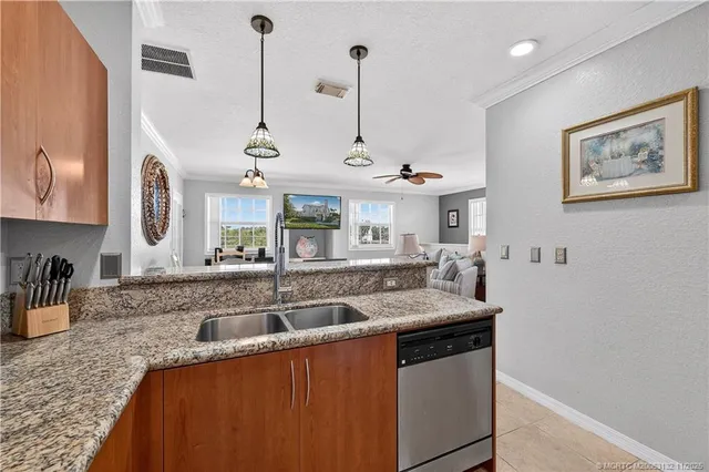 a kitchen with stainless steel appliances granite countertop a sink a stove and a wooden floors