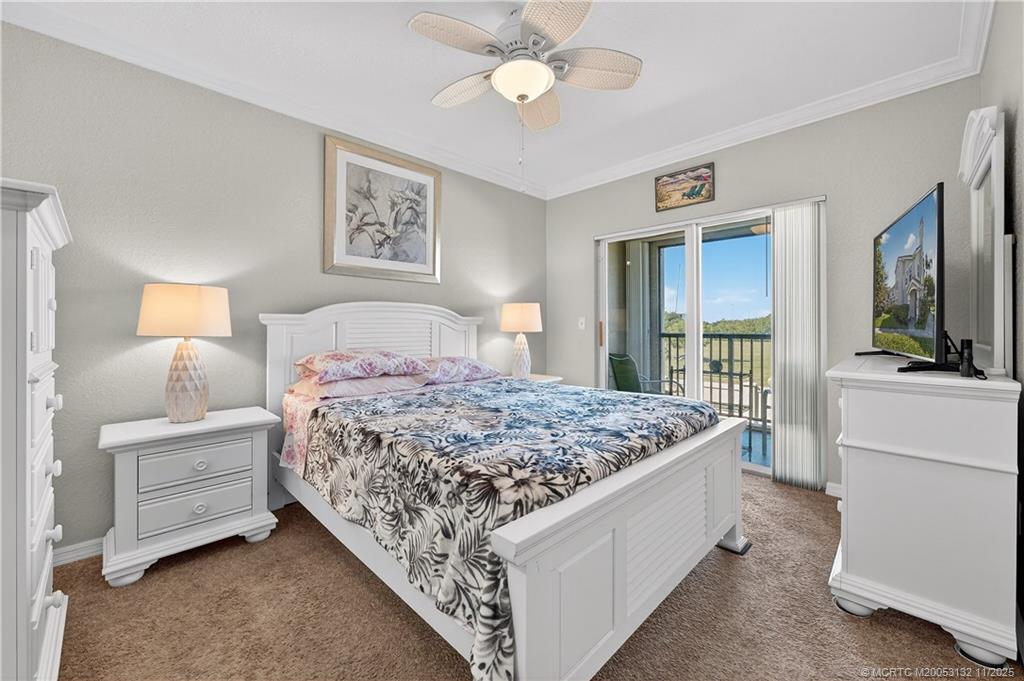 160 Southwest Peacock Boulevard, Unit 31203 Port St. Lucie, FL 34986 - Photo 18 of 43 a bedroom with a bed and a chandelier