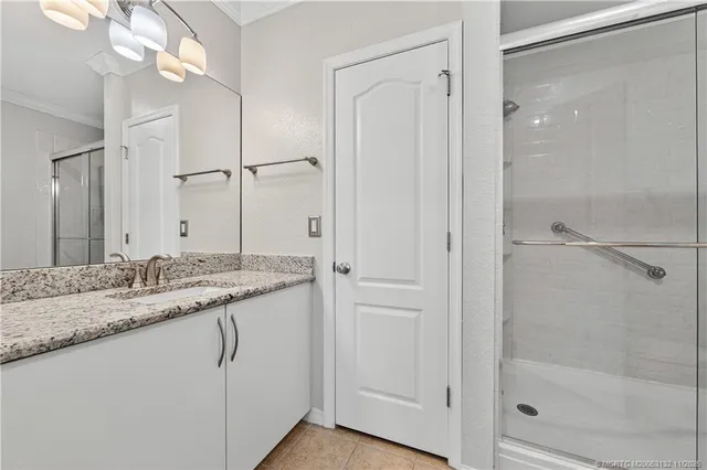 a bathroom with a granite countertop sink a mirror and a shower