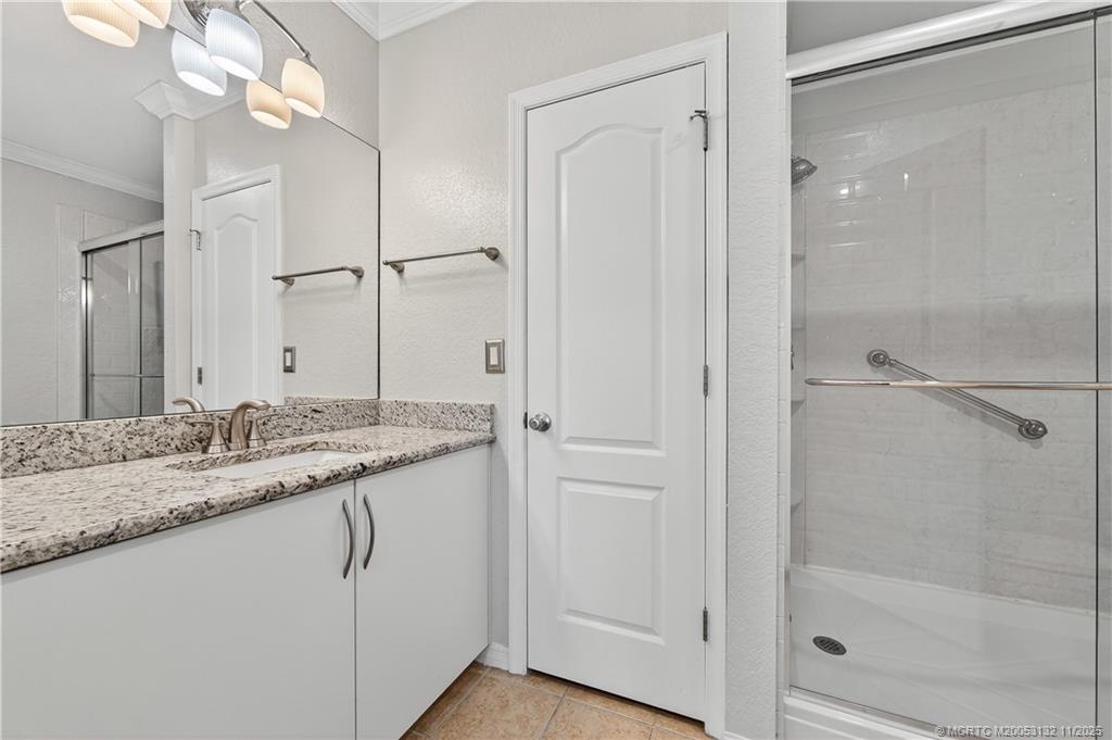 160 Southwest Peacock Boulevard, Unit 31203 Port St. Lucie, FL 34986 - Photo 20 of 43 a bathroom with a granite countertop sink a mirror and a shower