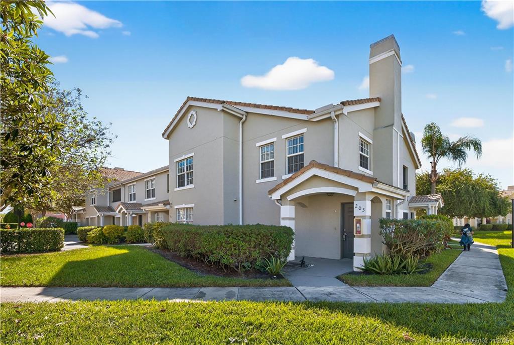 160 Southwest Peacock Boulevard, Unit 31203 Port St. Lucie, FL 34986 - Photo 42 of 43 a front view of a house with a yard and garage