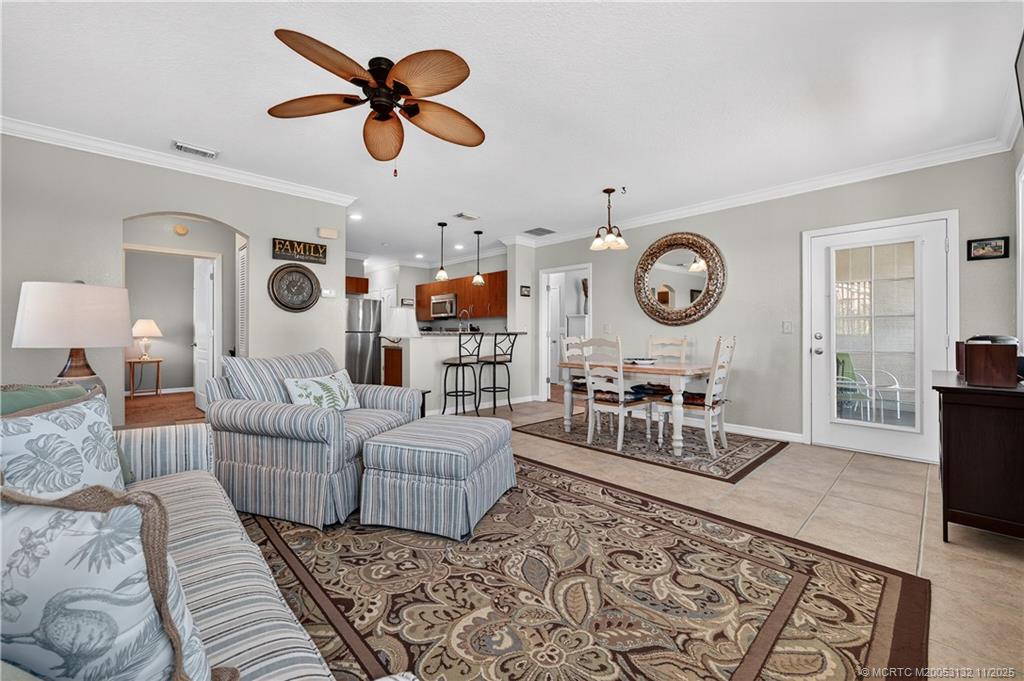 160 Southwest Peacock Boulevard, Unit 31203 Port St. Lucie, FL 34986 - Photo 10 of 43 a living room with furniture a rug and a clock