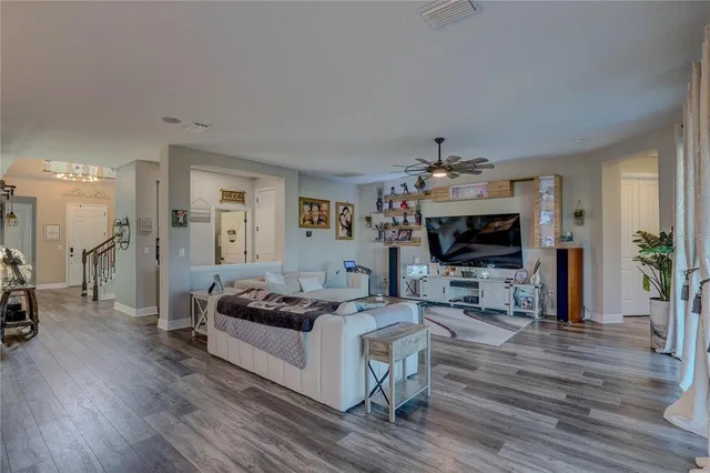 a living room with furniture a flat screen tv and a large window