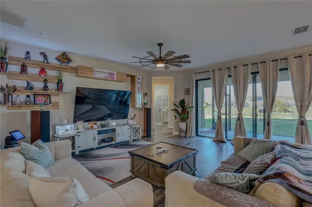 a kitchen with stainless steel appliances kitchen island granite countertop a dining table chairs refrigerator and sink