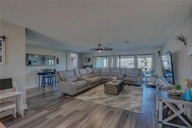 a large kitchen with a large window a sink stainless steel appliances and cabinets