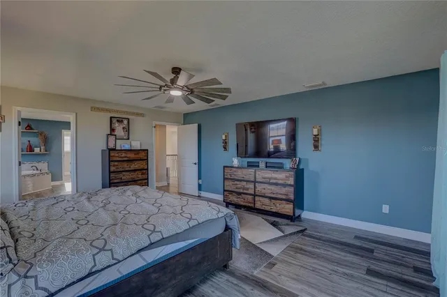 a bedroom with a bed and a ceiling fan