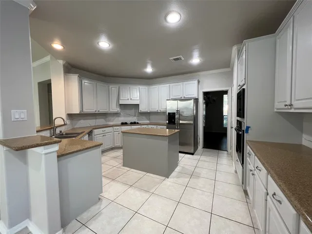 a kitchen with stainless steel appliances granite countertop a refrigerator sink and cabinets