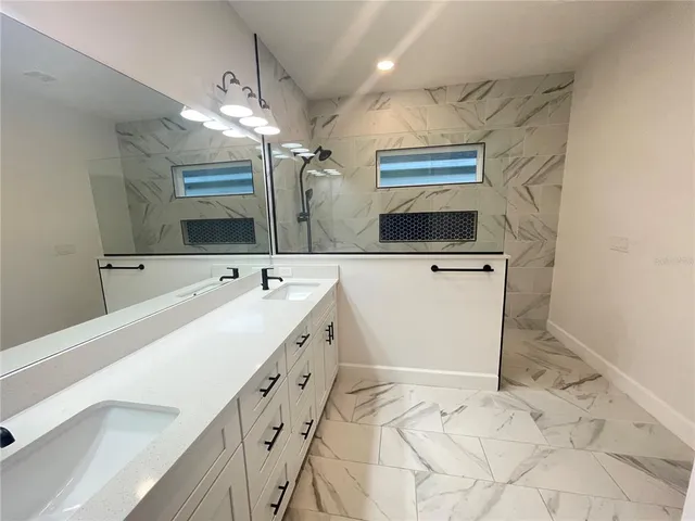 a bathroom with a sink a mirror and a shower