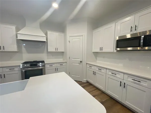 a kitchen with kitchen island white cabinets and stainless steel appliances