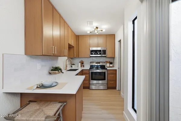 a kitchen with stainless steel appliances granite countertop a refrigerator sink and stove